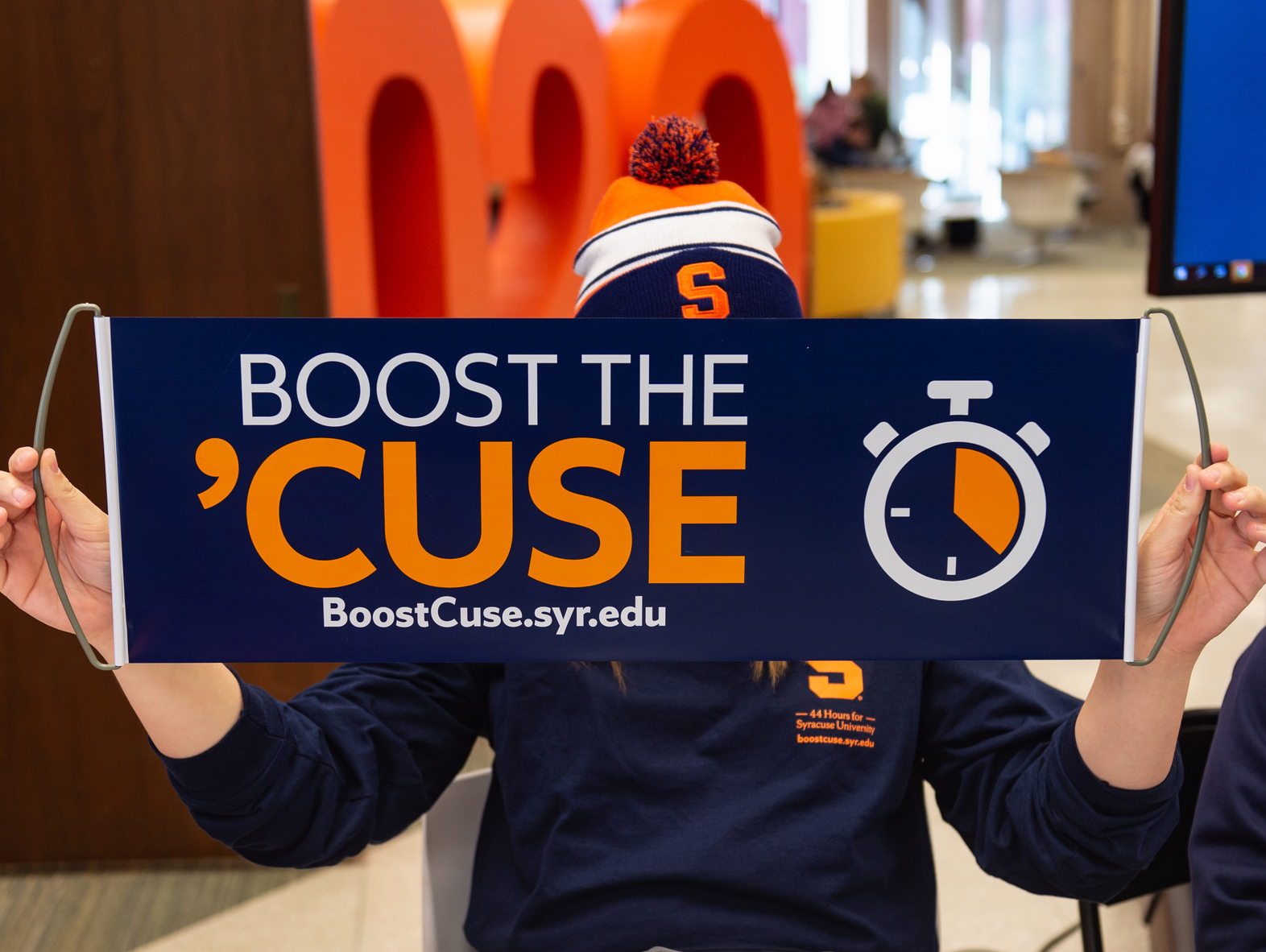 Person holding Boost the Cuse sign