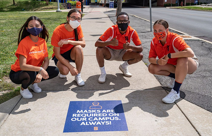 Four students wearing masks on campus