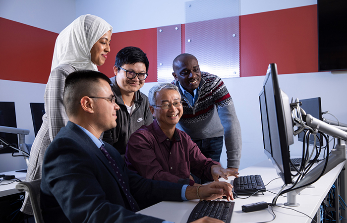 Electrical engineering and computer science professor Kevin Du working with students in Cybersecurity