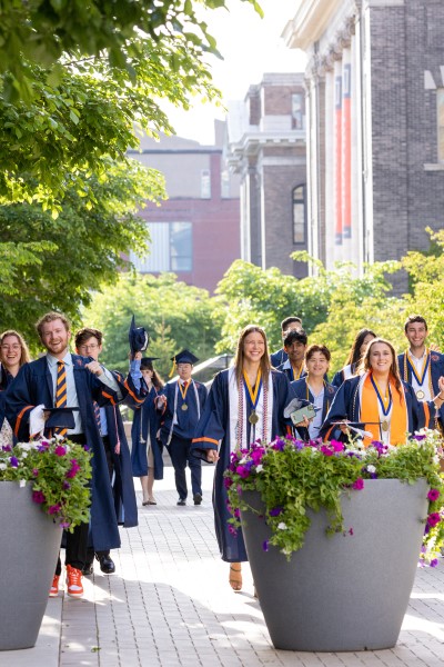 Graduates walking across campus displayed in a new window