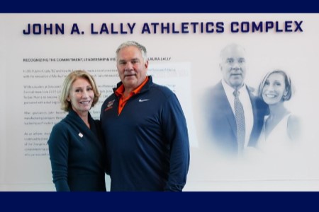 John A. ’82 and Laura Lally cut the ribbon to officially mark the opening of the John A. Lally Athletics Complex entranceway.